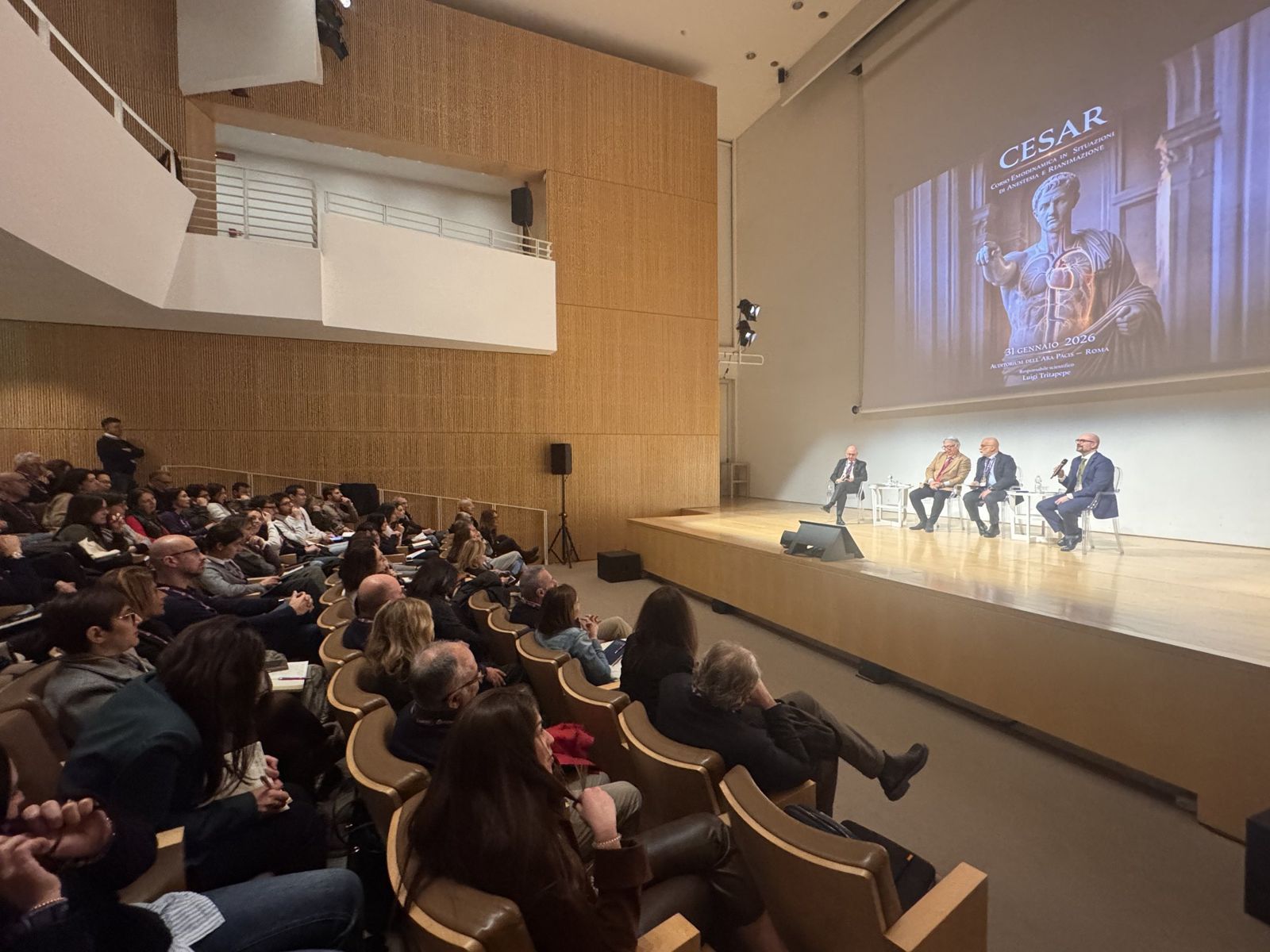 Il panel seduto sul palco davanti a una sala