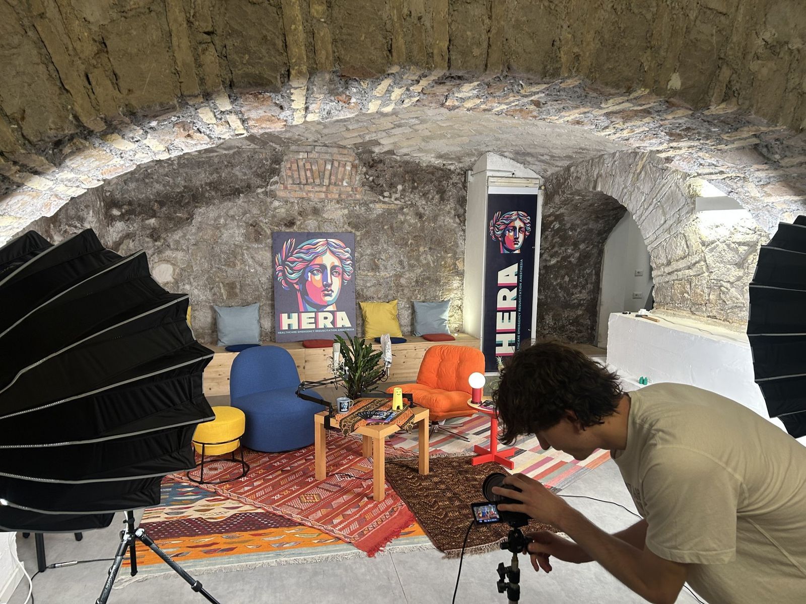 Set con poltrone colorate, luci e un fotografo al lavoro